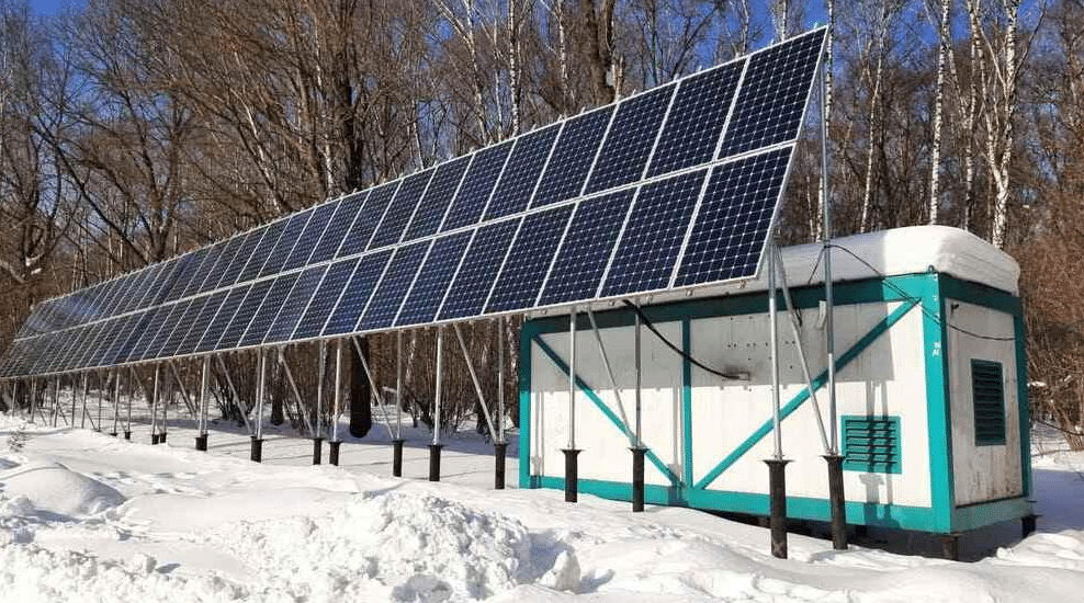 structure de panneaux photovoltaïques dans la neige au-dessus d'un local de BESS Stockage